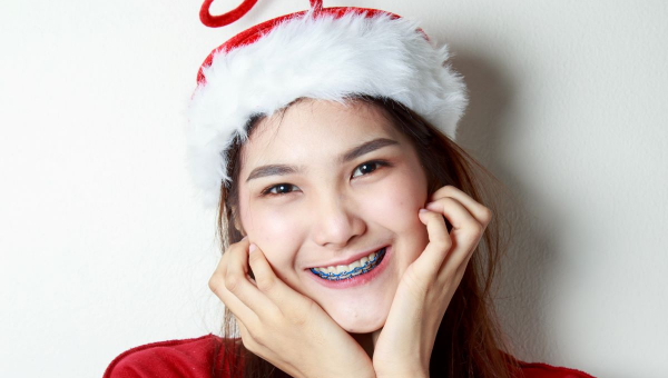 Girl with South Houston braces smiling for the holidays in Santa hat.