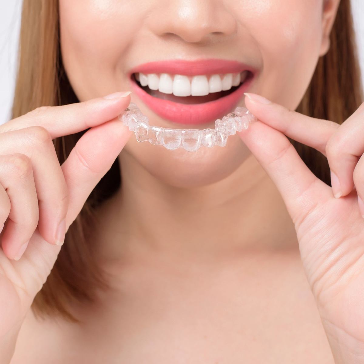 A smiling woman with Invisalign