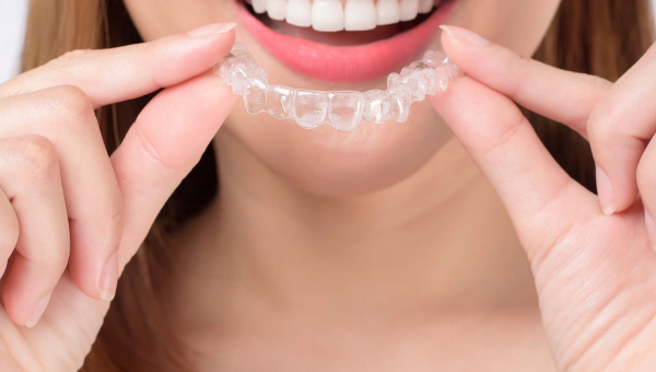 A smiling woman with Invisalign