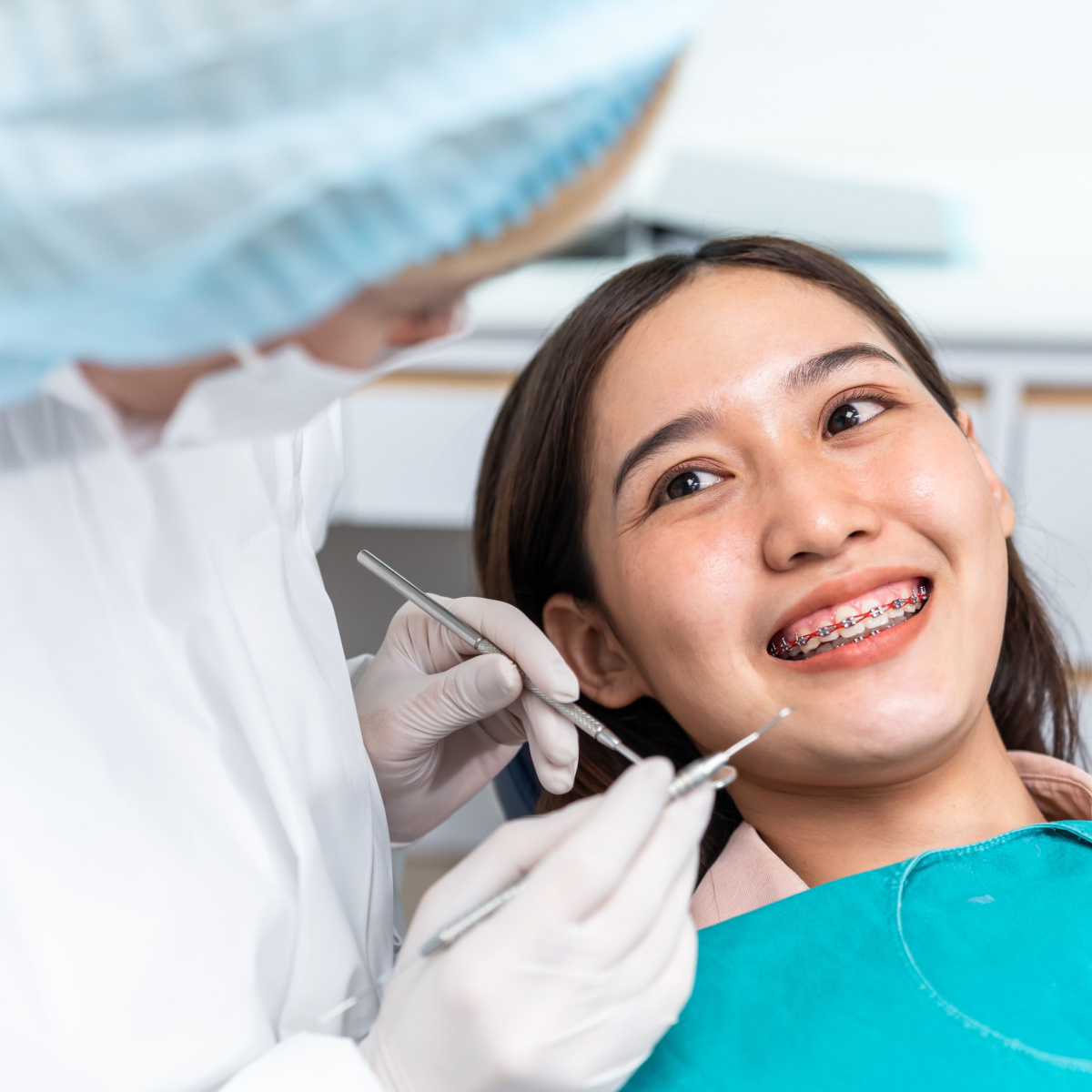 Houston dentist adjusts tightening patient’s dental braces.
