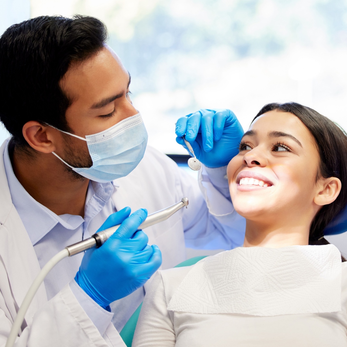 A Houston dentist cleaning a young patient's teeth