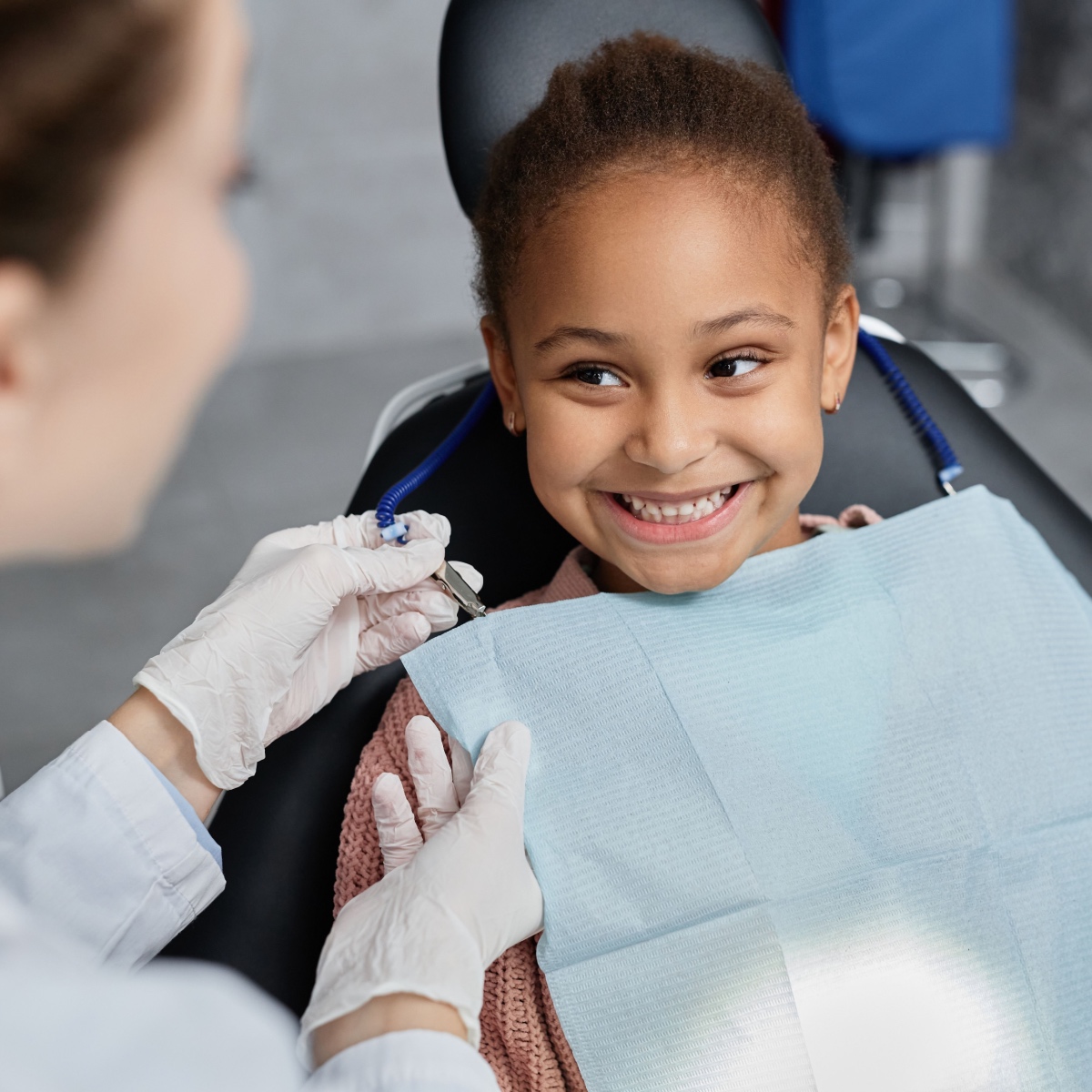 A smiling child sitting on a dental chair