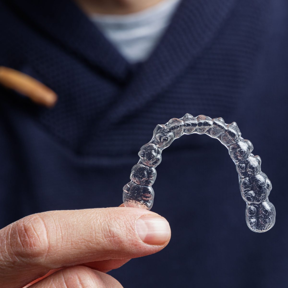 A dentist holding Invisalign