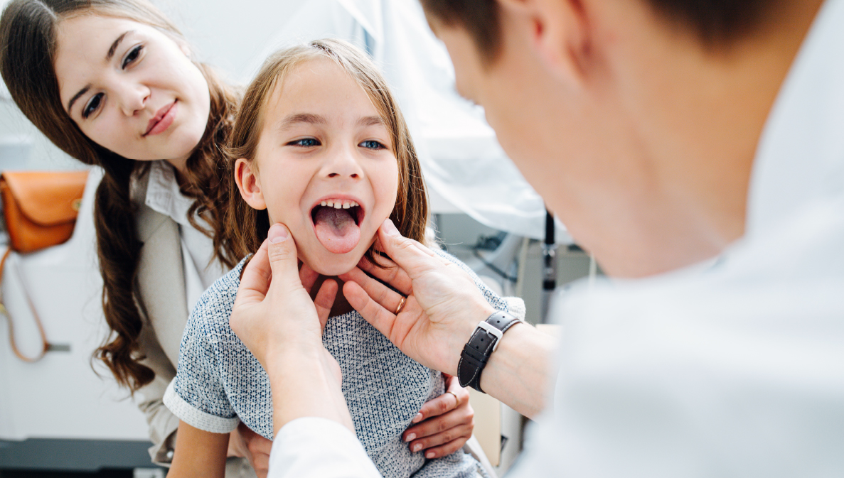 little girl having throat examined by pediatrician
