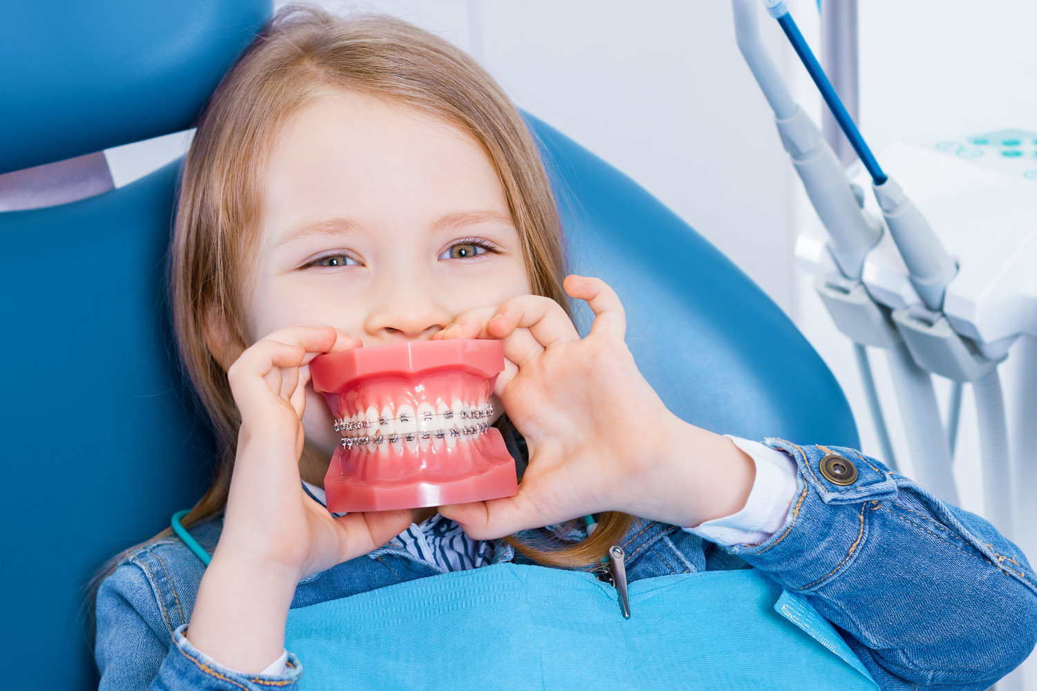 A Houston dentist cleaning a young patient's teeth