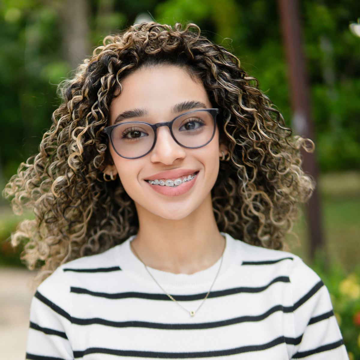 Woman of mixed race maintains healthy smile during Houston braces treatment.