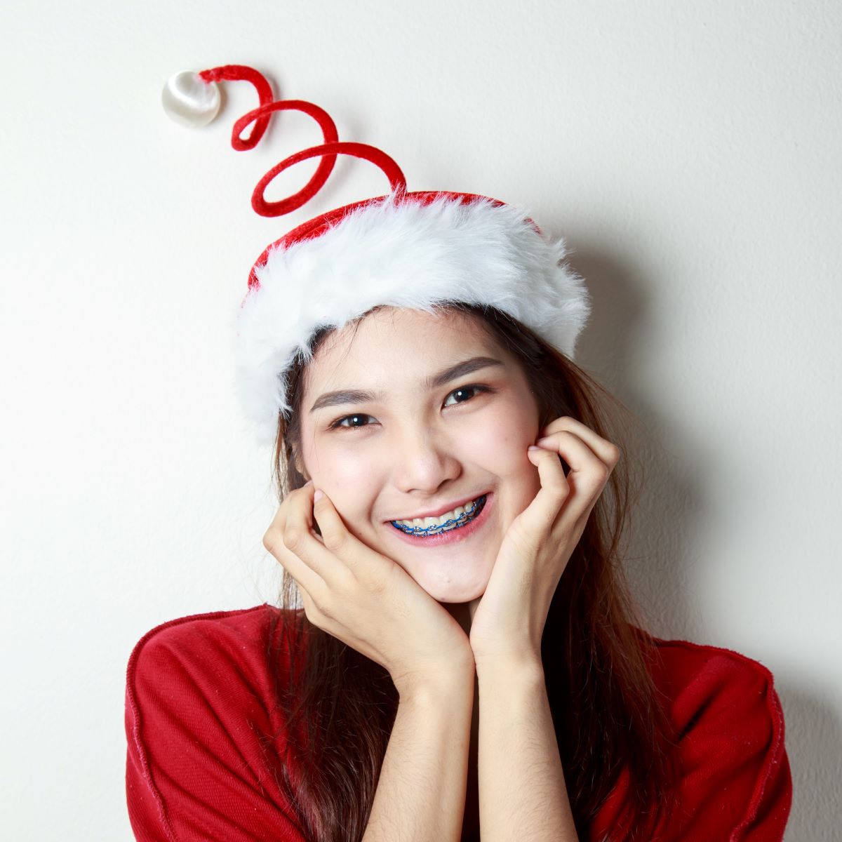 Girl with South Houston braces smiling for the holidays in Santa hat.