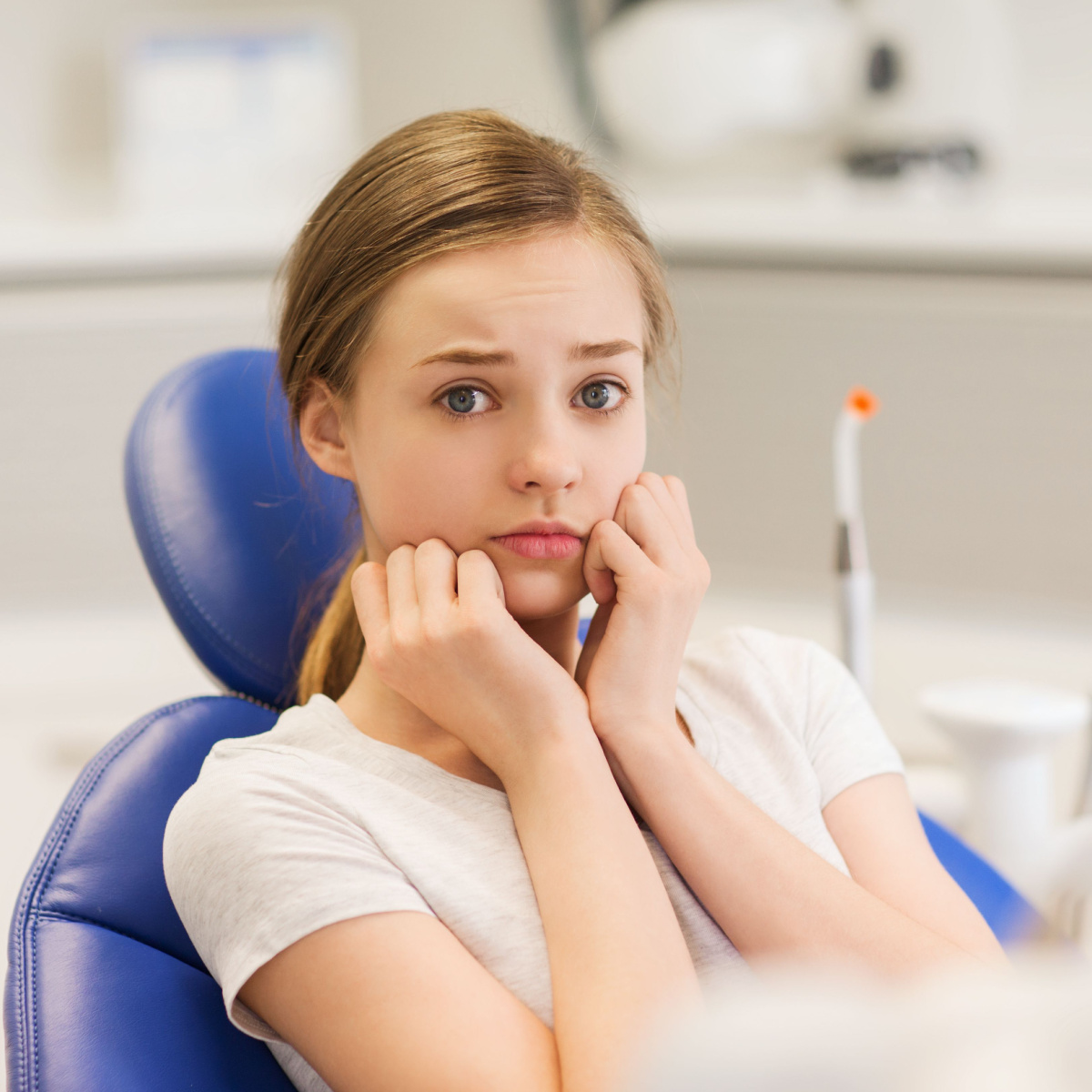 Teen woman experiencing dental anxiety consults her Houston family dentist.