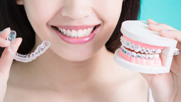 woman choosing between clear aligners and traditional braces